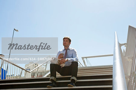 Businessman sitting on city steps