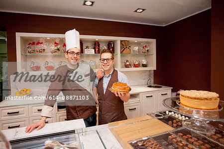 Baker and cashier smiling in bakery