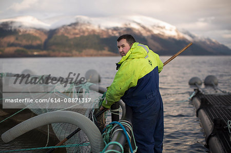 Worker at salmon farm in rural lake