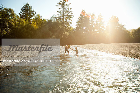 Mother with two children playing in river