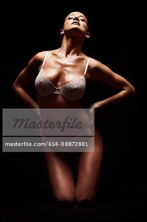 Woman in lingerie against black background
