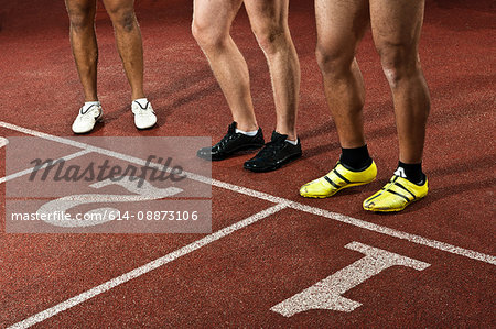 Athletes preparing to race on sportstrack, low section