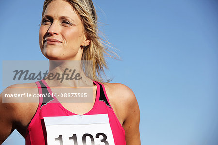 Mid adult woman in sports vest against blue sky
