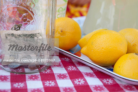 Dollar bills in jar with fresh lemons