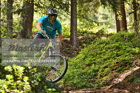 Mountain biker riding off road in forest