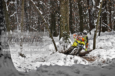 Mountain biker riding forest track in snow