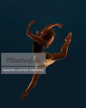 Young female dancer leaping mid air