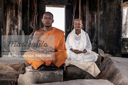 Senior and young monk meditating in temple in Angkor Wat, Siem Reap, Cambodia