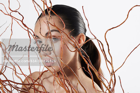 Woman looking at camera behind twigs