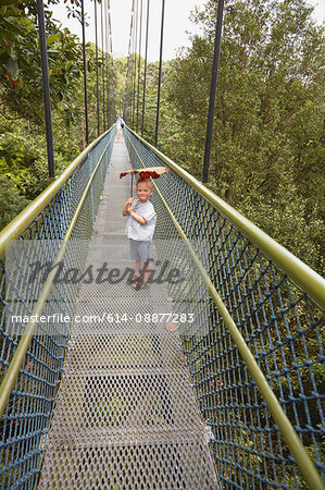 Boy standing on long footbridge, Botanical Gardens, Singapore