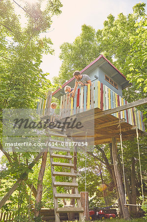 Father and two sons, painting tree house