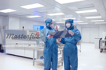 Male worker holding flex circuit in flexible electronics factory clean room
