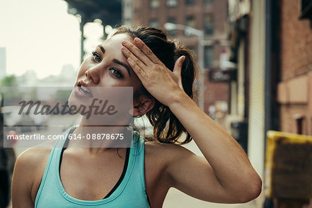 Young female runner wiping her brow, New York, USA