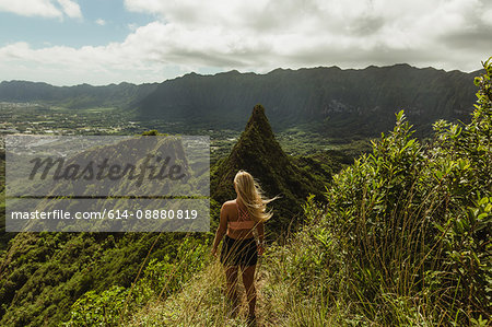 Rear view of woman on grass covered mountain, Oahu, Hawaii, USA