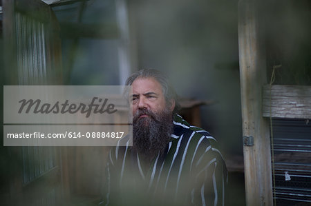 Mature man with beard, sitting outdoors