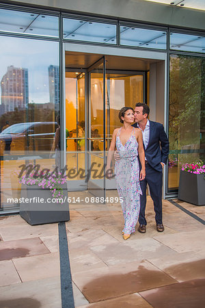 Couple standing together outside building, wearing evening clothes