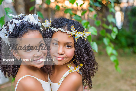 Portrait of two girls, wearing butterflies in hair