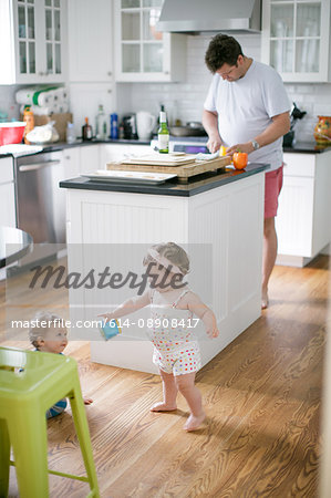 Mature man preparing fruit for toddlers in kitchen