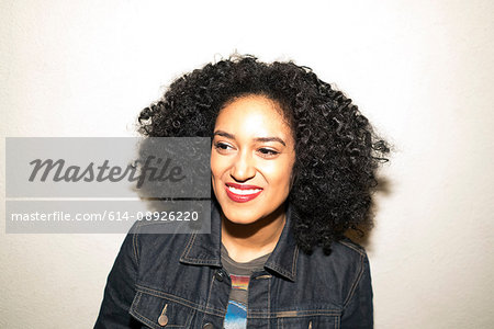 Portrait of curly haired woman looking away smiling
