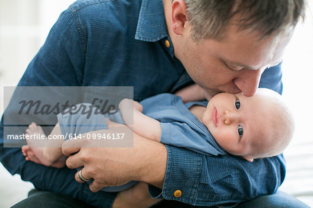 Father holding and kissing baby boy