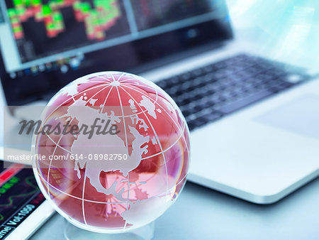 Globe with digital tablet and laptop showing international business trade