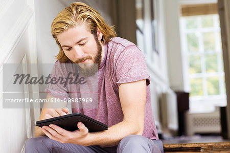 Male designer using digital tablet on creative studio step