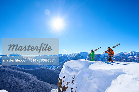 Two male skiers looking out from snow covered ridge, Aspen, Colorado, USA