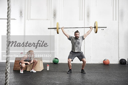 Man lifting barbell in cross training gym