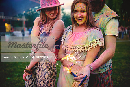 Portrait of two young women and covered in coloured chalk powder at festival