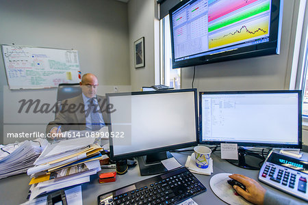 Businessman reading paperwork at office desk