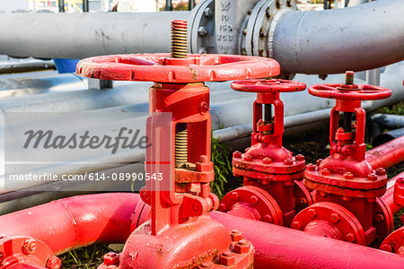 Close up of red industrial pipes and valves at biofuel industrial plant