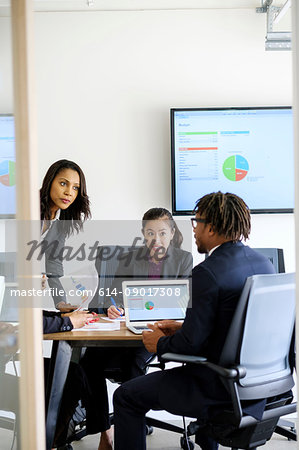 Businessman and businesswomen, sitting in office, having discussion, looking at data