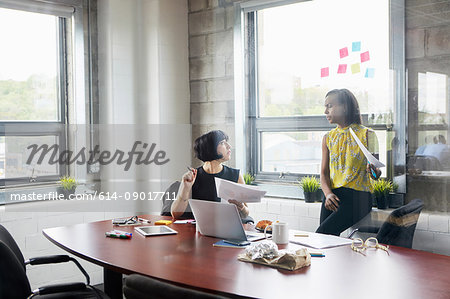 Two women working together in meeting room, brainstorming