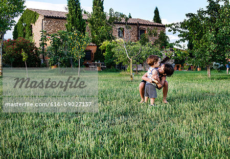 Brothers playing in garden of farmhouse