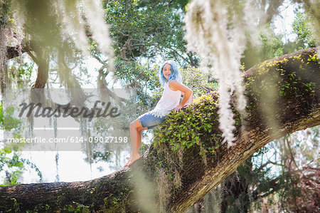 Girl sitting on old oak tree
