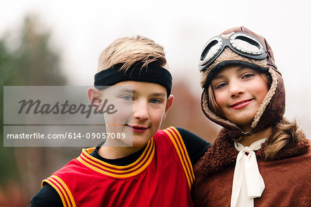Portrait of boy and twin sister wearing basketball and pilot costumes for halloween