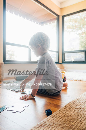 Boy sitting on floor doing jigsaw puzzle