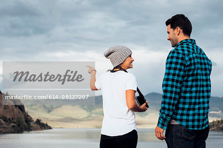 Couple standing on wall beside Dillon Reservoir, looking at view, Silverthorne, Colorado, USA