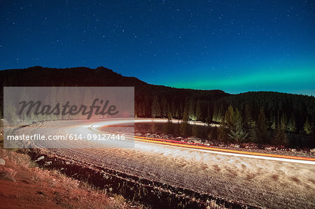 Northern lights, and long exposure light trails from vehicles on road, Nickel Plate Provincial Park, Penticton, British Columbia, Canada