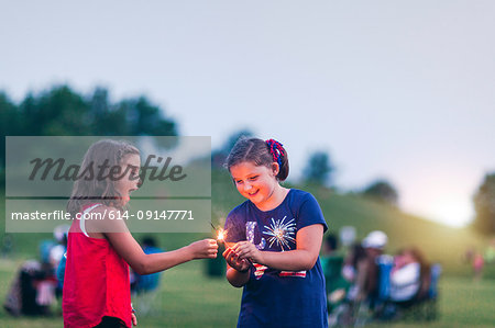 Girls holding sparklers smiling
