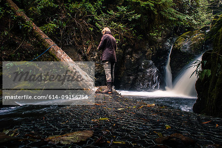 Mature woman exploring rural surroundings, rear view, Vancouver Island, Canada