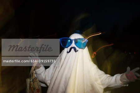 Girl dressed as ghost with mustache and over sized sunglasses, blurred