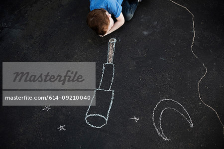 Boy on floor looking at chalk drawing