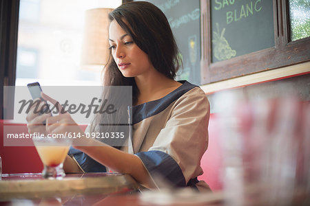Mid adult women using mobile phone in restaurant