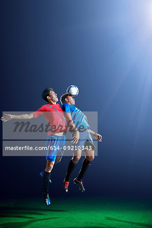 Male soccer players heading ball