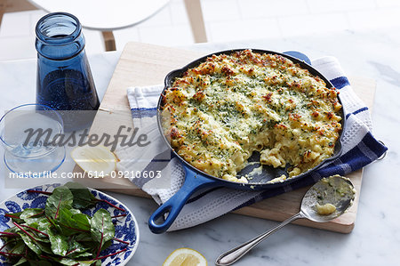 Meal with pan of macaroni cheese and salad leaf