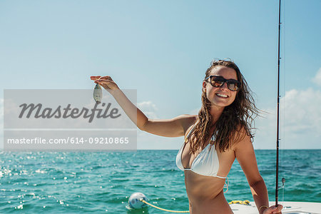 Young woman on boat holding fish, Islamorada, Florida Keys, USA
