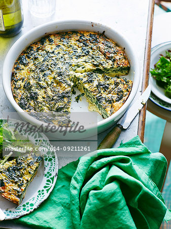 Dish of silverbeet and feta frittata with portion on plate