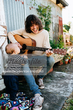 Father entertaining son with guitar