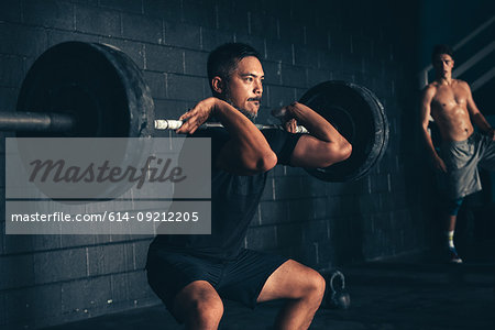 Male crossfitter lifting barbell in gym